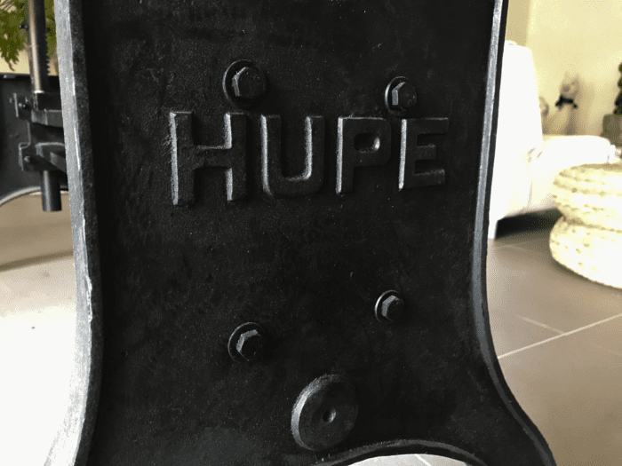 Un pied de table ajustable en fonte avec les lettre HUPE